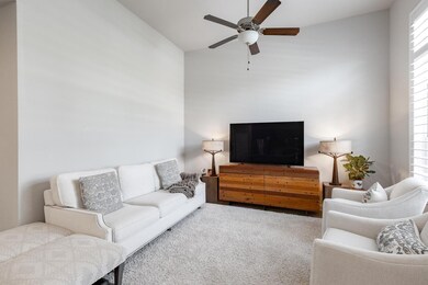 Living area featuring a ceiling fan, carpet, and 