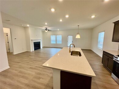 Kitchen featuring ceiling fan, light wood-style floors, stainless steel range oven, recessed lighting, and a center island with sink