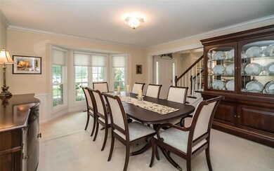 Dining room boasts bay window, crown molding, chai