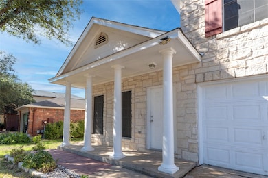 Property entrance with covered porch, stone siding, and a garage