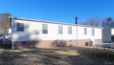 Back of property with crawl space, a trampoline, a