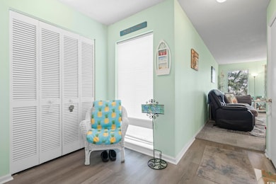 Sitting room with baseboards and wood finished flo