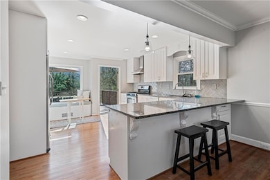 Kitchen with crown molding, a sink, wall chimney e