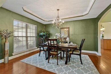 SPACIOUS DINING ROOM WITH TRAY CEILING AND HARDWOO