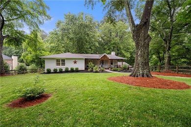 View of front of property featuring a chimney, stucco siding, a porch, and asphalt driveway