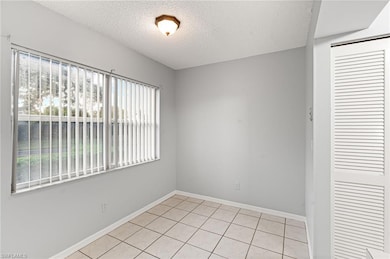 Empty room featuring a textured ceiling and light tile patterned floors