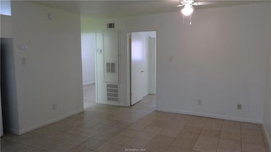 Spare room with baseboards, a ceiling fan, visible