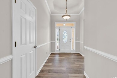 Foyer entrance with crown molding, a raised ceilin
