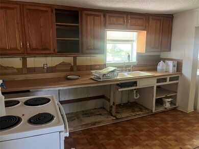 Kitchen with tasteful backsplash, a textured ceili