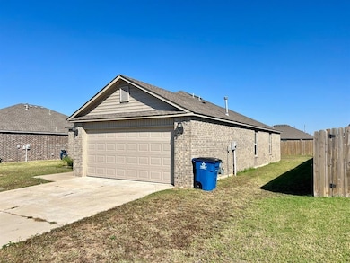 View of side of property featuring brick siding, driveway, and a garage
