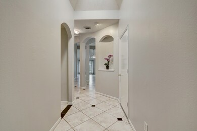 This view from the entry gives a great hint at what is ahead. The garage is through the door to the right. The arched opening on the left leads to the laundry, hall bath, and two secondary bedrooms. You can see through the formal dining room, and into the living room. Let's go see the rest!