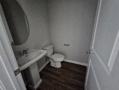 Half bath featuring toilet and wood finished floo