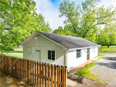 View of side of property featuring roof with shingles and concrete block siding