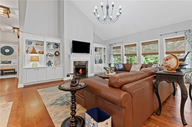 Vaulted ceiling with eye popping chandelier, gas fireplace, and custom boookcases.