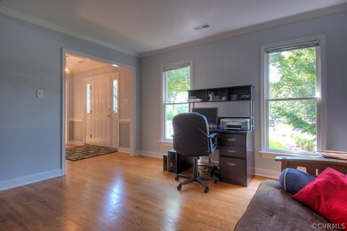 Formal living room with hardwood floors and crown