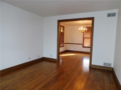 Living room with gleaming hardwood floors and pock
