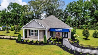 View of front facade with brick siding, fence, and a front yard