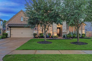 This home offers beautiful curb appeal including brick and stone elevation with nighttime lighting, and manicured landscape.