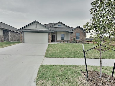Single story home with brick siding, an attached garage, driveway, and a front lawn