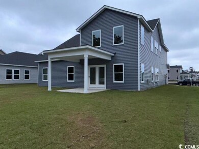 Rear view of house featuring a lawn and a patio