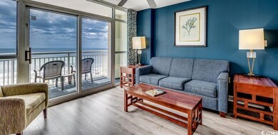 Living room with healthy amount of natural light, wood finished floors, a water view, and a ceiling fan