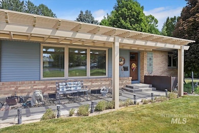 View of front facade with brick siding, a front lawn, and a pergola