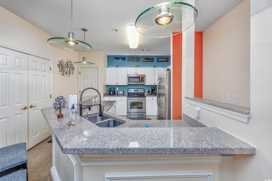 Kitchen featuring white cabinets, hanging light fi