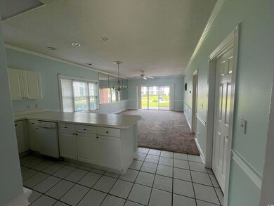 Kitchen with white dishwasher, crown molding, light colored carpet, a peninsula, and white cabinets