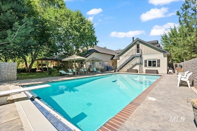 View of swimming pool with a diving board, stairs, and a patio area