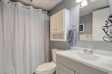 Bathroom featuring curtained shower, toilet, a dro