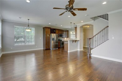 Unfurnished living room featuring ceiling fan, ar