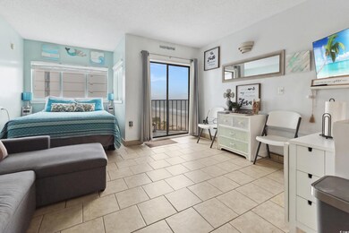 Bedroom featuring access to outside, a textured ceiling, and light tile patterned floors