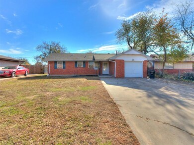 Ranch-style house with a garage and a front lawn
