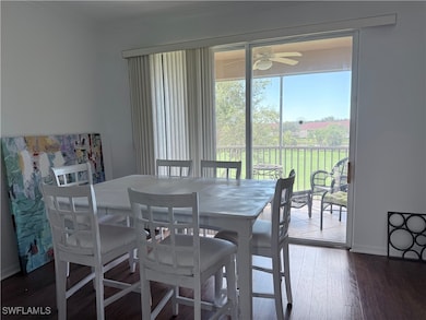 Dining space with dark wood-style flooring and crown molding