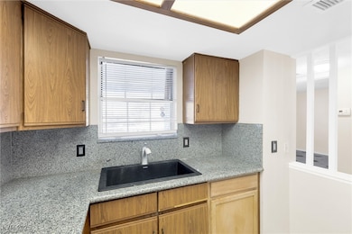 Kitchen with decorative backsplash, a sink, and li