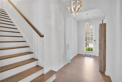 Foyer entrance with baseboards, arched walkways, a