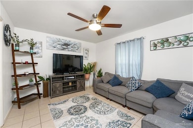 Living room featuring ceiling fan and light tile patterned flooring