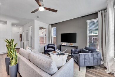 Living area with visible vents, ceiling fan, and wood finished floors