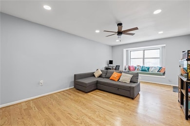 Living room featuring a ceiling fan, light wood-style flooring, recessed lighting, and baseboards