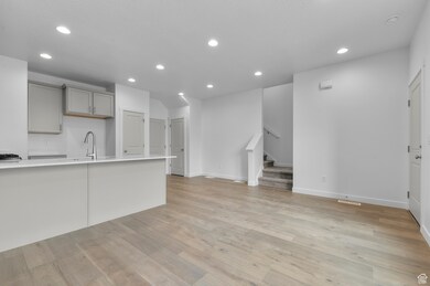 Interior space with stairway, light wood-type flooring, recessed lighting, and a sink