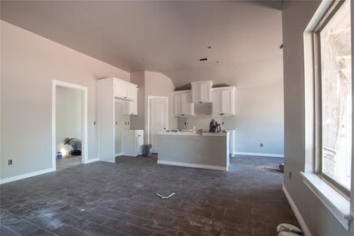 Kitchen featuring white cabinets, dark tile floori