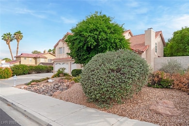 View of front facade featuring stucco siding, a tile roof, driveway, a garage, and a residential view