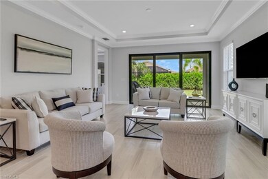 Living area featuring a tray ceiling, a wealth of natural light, and baseboards