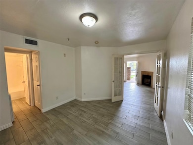Empty room featuring a textured ceiling, wood fini