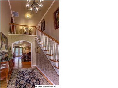 Grand foyer with beautiful chandelier and hardwood