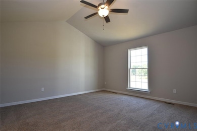 Carpeted spare room with vaulted ceiling and ceiling fan