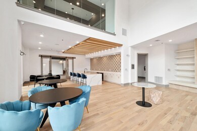 Dining area with sink, a high ceiling, light hardw