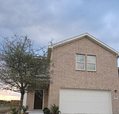 View of front of property with a garage, brick siding, and driveway