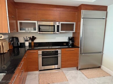 Kitchen featuring dark stone counters, light tile