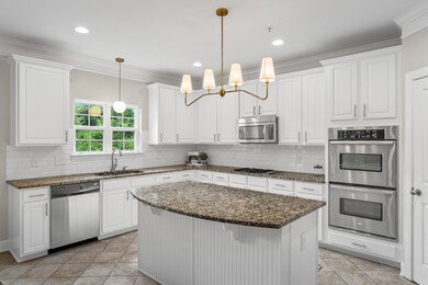 A large bar for seating, double ovens, and a gas cooktop